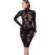 Une femme élégante portant une robe résille noire, posant dans un cadre sombre et sensuel.